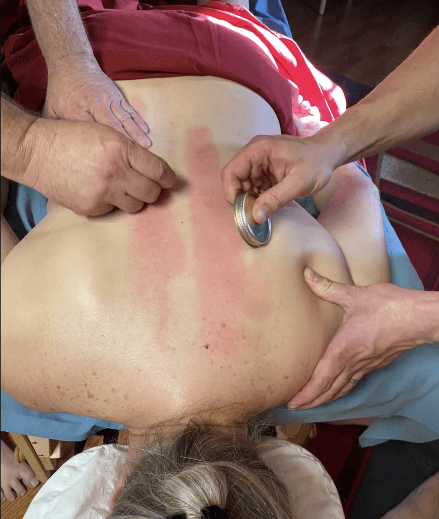 A person is getting their back examined by two hands.