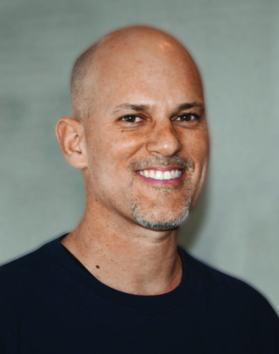 A man with bald head smiling for the camera.