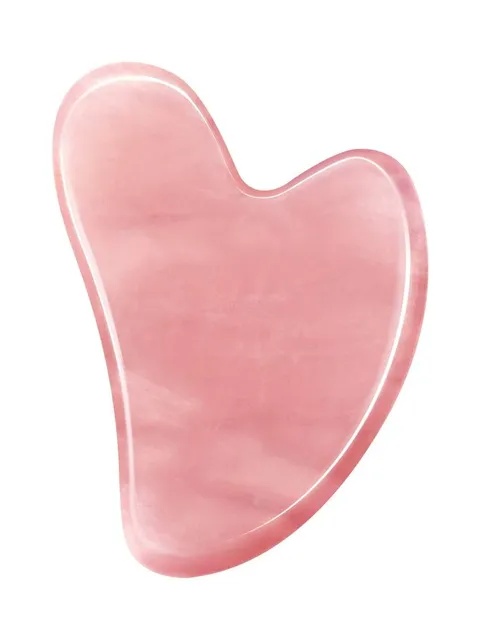 A pink heart shaped soap is sitting on the counter.