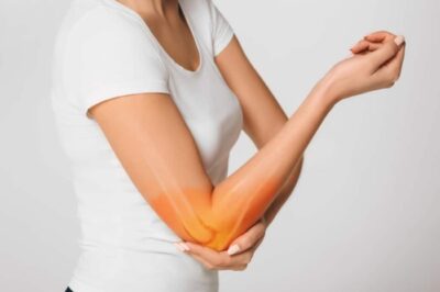 A woman holding her elbow in pain.